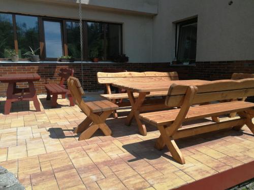 a wooden picnic table and benches on a patio at Penzion U Klujů in Věstín