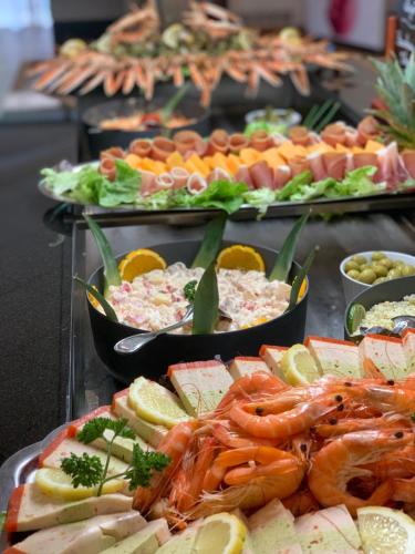 a buffet of food with shrimp and other foods at Les Hameaux De Lozere Sure Hotel Collection by Best Western in Fournels