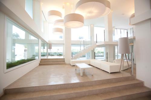 a lobby with white furniture and large windows at Villa Del Mare Spa Resort in Cervia