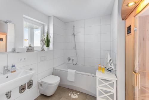 ein weißes Bad mit einem WC und einem Waschbecken in der Unterkunft Meeresperle in Olpenitz