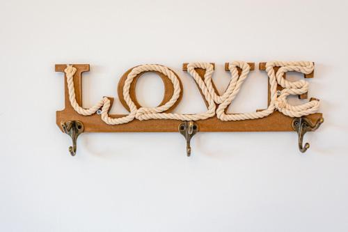 a rope sign that says love on a wall at Hostel & Apartments Kołobrzeg in Kołobrzeg