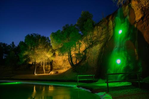 a green light next to a swimming pool at night at Hospedium Hotel La Parada del Compte in Torre del Compte