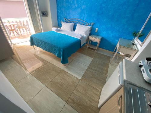 1 dormitorio con cama y pared azul en Villa Antonis, en Parga