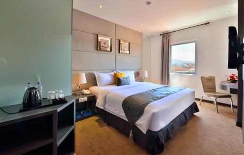 una camera d'albergo con un letto, una scrivania e una finestra di Serela Merdeka by KAGUM Hotels a Bandung