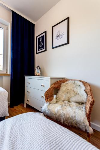 a bedroom with a bed and a dresser with a bed sqor at Hostel & Apartments Kołobrzeg in Kołobrzeg