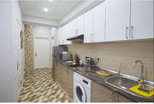a kitchen with a sink and a washing machine at Leyla Apartments 1 in Baku