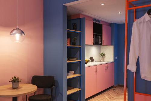 a kitchen with pink and blue walls and a table at Holiday Inn - the niu, Belt Frankfurt Eschborn by IHG in Eschborn