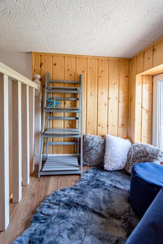 a living room with a wooden wall and a ladder at Hostel & Apartments Kołobrzeg in Kołobrzeg