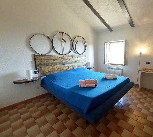 Un dormitorio con una cama azul con espejos en la pared en La fonte di Gaiche, en Piegaro