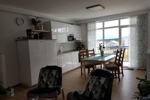 a kitchen and dining room with a table and chairs at Living Home, apartament cu două dormitoare și două băi in Cisnădie