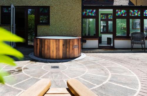 a wooden tub sitting in a courtyard with two benches at Grove Lodge in Gosport