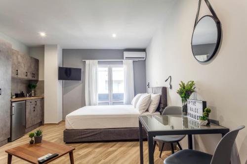 a bedroom with a bed and a desk and a table at Raise Heraklion Boutique Apartments in Heraklio Town