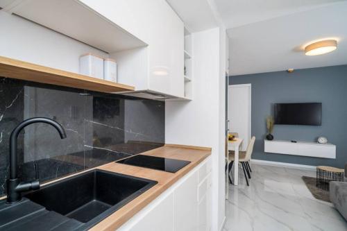 een keuken met een wastafel en een woonkamer bij Luxury Downtown West Apartment Dubrovnik in Dubrovnik