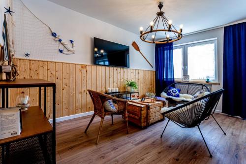 a living room with a couch and a table and chairs at Hostel & Apartments Kołobrzeg in Kołobrzeg