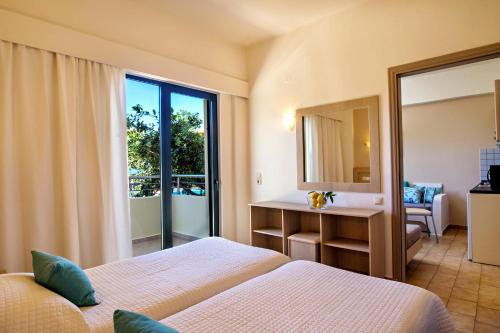 una camera d'albergo con due letti e uno specchio di Lefka Apartments a Parigoría
