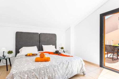 a bedroom with a large bed with an orange object on it at Tenerife South Apartments in Playa de las Americas