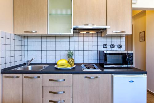 a kitchen with a sink and a plate of fruit at Lefka Apartments in Parigoría