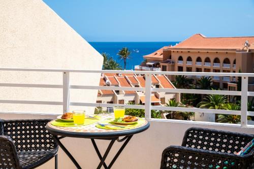 a table with food and drinks on a balcony at Tenerife South Apartments in Playa de las Americas