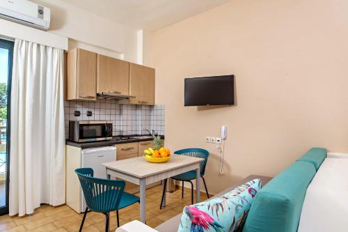 a kitchen and a living room with a table and chairs at Lefka Apartments in Parigoría