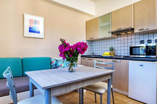 a kitchen with a table with a vase of flowers on it at Lefka Apartments in Parigoría