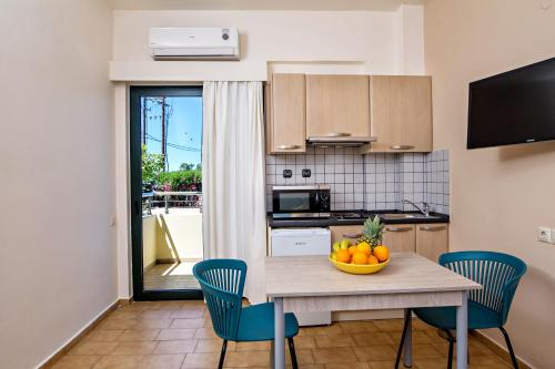 a kitchen with a table with a bowl of fruit on it at Lefka Apartments in Parigoría