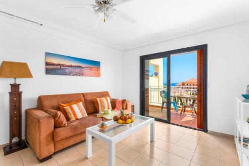 a living room with a couch and a table at Tenerife South Apartments in Playa de las Americas