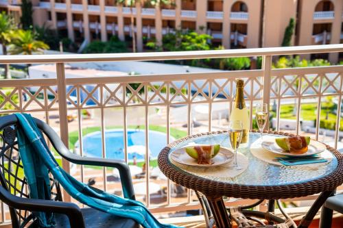 a table with a bottle of wine and a glass at Tenerife South Apartments in Playa de las Americas