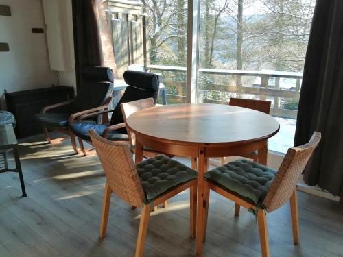 uma mesa de madeira e cadeiras num quarto com uma janela em Au repos de Zoé em Waulsort