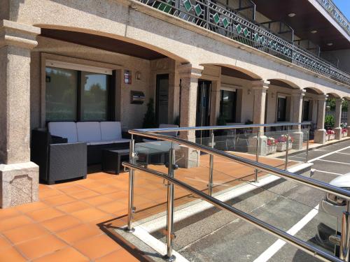 an outdoor patio with white benches on a building at Hotel Florida in A Lanzada