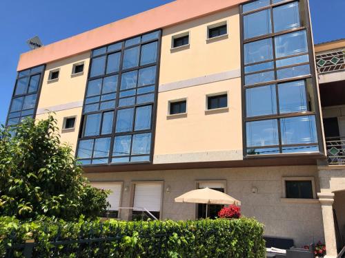 an apartment building with an umbrella in front of it at Hotel Florida in A Lanzada