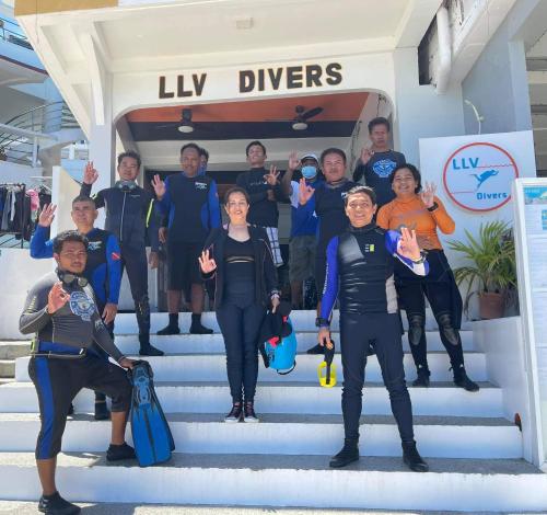 a group of people standing on stairs in front of a boat at Lalaguna Villas Luxury Dive Resort and Spa in Puerto Galera