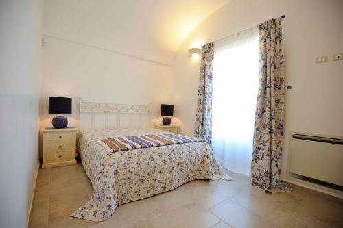 a bedroom with a bed and a window at Agriturismo Arco di Sole in Alberobello