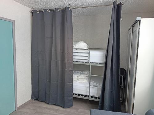 Habitación con cortina de ducha y litera en Résidence cambielh en Aragnouet