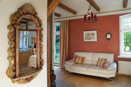 a living room with a white couch and a mirror at Ferienhof Möltgen in Bosau