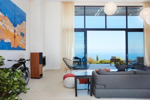 a living room with a couch and a table at Villa The Longhouse- Pool-Sauna-Gym- Panormaic Seaview in Sellía