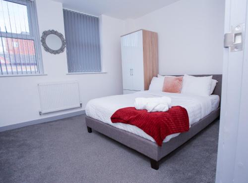 a bedroom with a bed with a red blanket at Cosy Executive City Apartment 2 in Doncaster