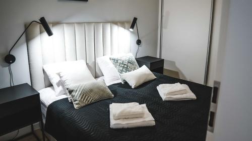 a bedroom with a bed with towels on it at Residence Polanica z sauną, Sun & Snow in Polanica-Zdrój