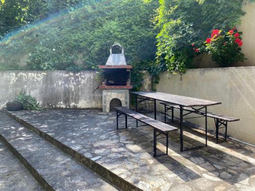 two picnic tables and a grill in a backyard at Studios in Complex Colosseum in Kranevo