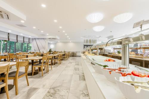 a restaurant with tables and chairs and a buffet at Centrum Zdrowia i Wypoczynku Ikar in Kołobrzeg