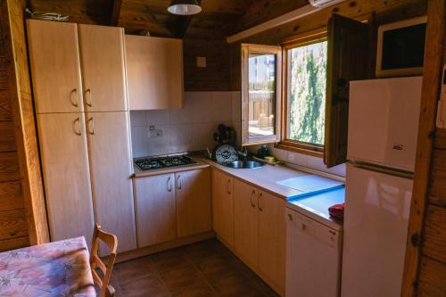 a kitchen with wooden cabinets and a refrigerator at Casa de madera con piscina privada in Los Alcázares