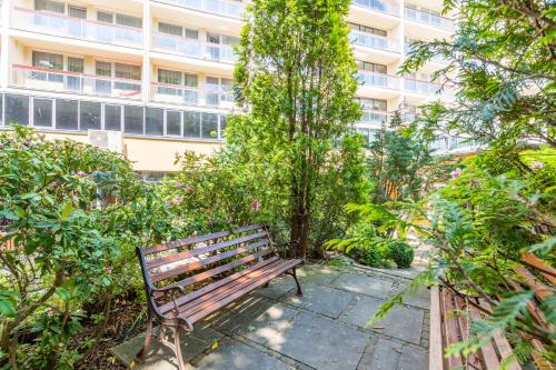 a park bench sitting in front of a building at Centrum Zdrowia i Wypoczynku Ikar in Kołobrzeg