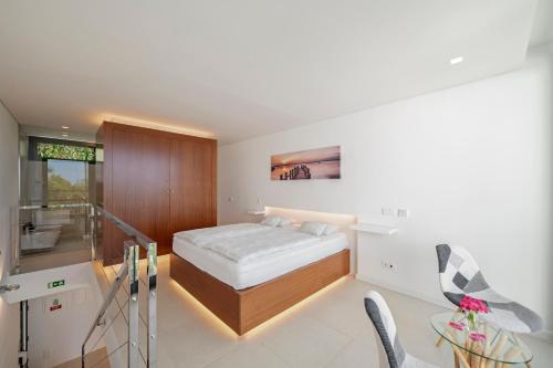a bedroom with a bed and a table and chairs at Quinta Golfinho in Arco da Calheta