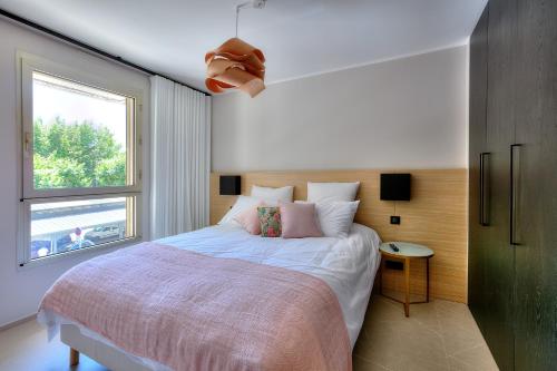 um quarto com uma cama grande e uma janela em CMG - Appartement de standing avec balcon - 2BR/6P - Cannes em Cannes