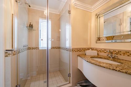 a bathroom with a sink and a shower at Lemon Tree Lane in Port Elizabeth