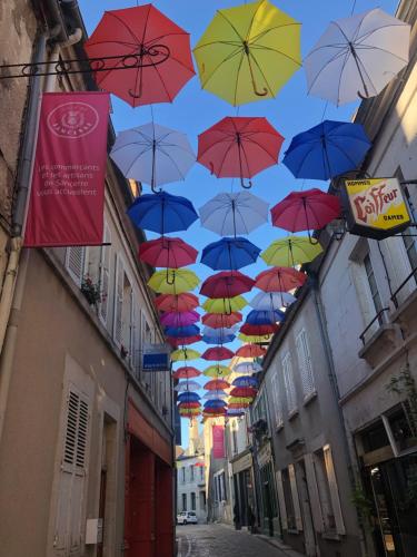 a bunch of umbrellas hanging over a street at Appartement centre historique Sancerre in Sancerre