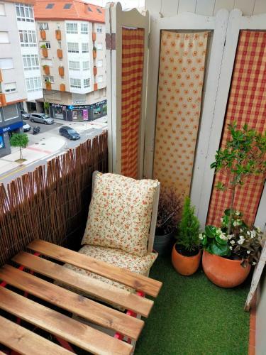 a chair sitting on a balcony with a window at Apartamento boutique "A casa de Lola" in Boiro