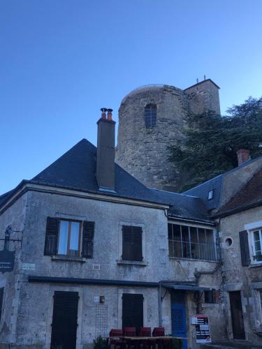 an old stone house with a castle in the background at Appartement centre historique Sancerre in Sancerre