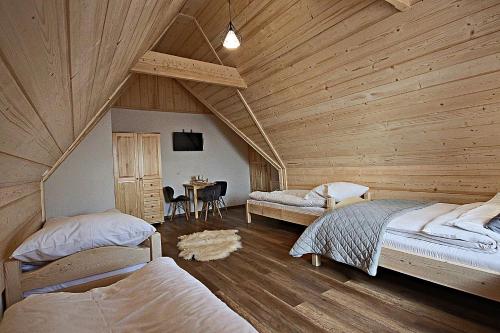 - une chambre avec 2 lits et une table dans l'établissement Tatra Widok, à Murzasichle