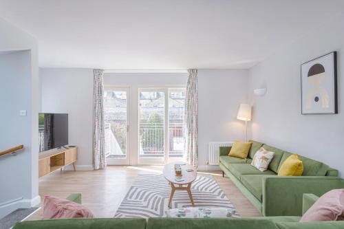 a living room with a green couch and a table at 3 Bedroom Jesus Green Townhouse with Parking in Cambridge