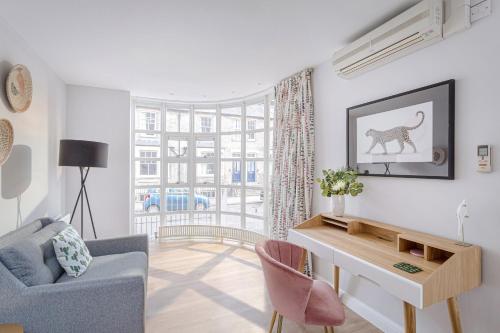 a living room with a couch and a desk and a window at 3 Bedroom Jesus Green Townhouse with Parking in Cambridge